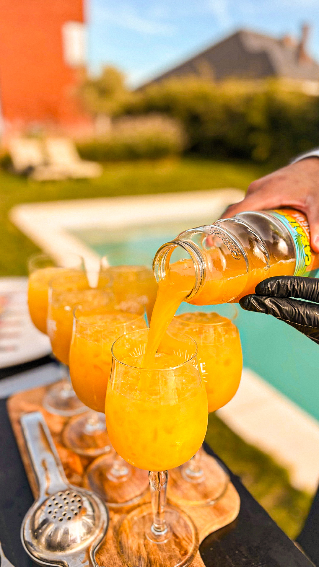 Mixologue préparant des cocktails frais au bord d'une piscine lors d'un événement privé
